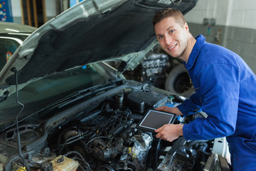 Auto mechanic by car with tablet pc