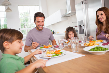 Obraz na płótnie Canvas Rodzina uśmiecha się wokół dobrego posiłku