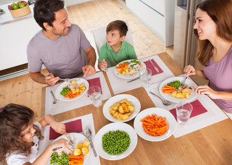 Family smiling around a healthy meal