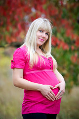 Woman holding her hands in a heart shape on her pregnant belly