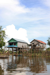 Reflets des maisons sur pilotis dans le lac