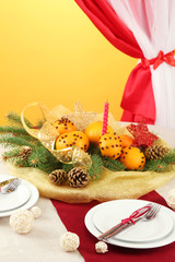 beautiful christmas table setting with tangerines and fir tree,