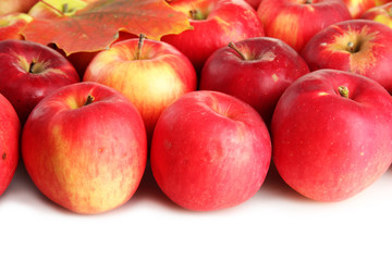juicy red apples with leaves, isolated on white