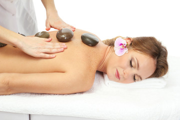 Obraz na płótnie Canvas beautiful woman in spa salon with spa stones getting massage,
