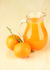 Fototapeta na wymiar Full jug of tangerine juice, on wooden background