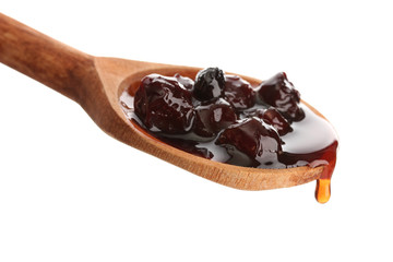 tasty berry jam in wooden spoon, isolated on white