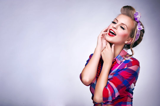 Beautiful young woman with pin-up make-up and hairstyle posing