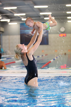 Mother and son in swimming pool, motion blurred image