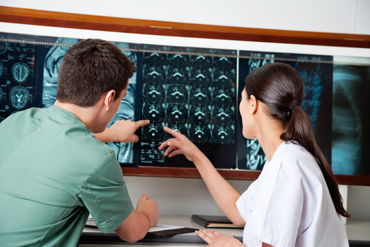 Medical Technicians Pointing At MRI X-ray
