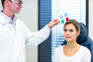 Optometry concept - pretty young woman having her eyes examined