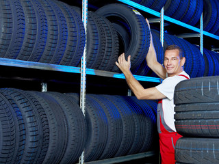 Car mechanic looking for a tire in a tire store