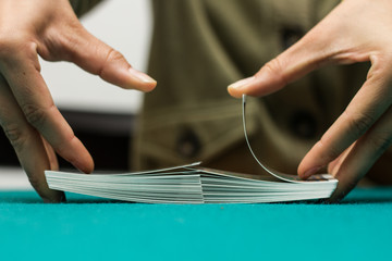 Manos de mujer mezclando, barajando las cartas.