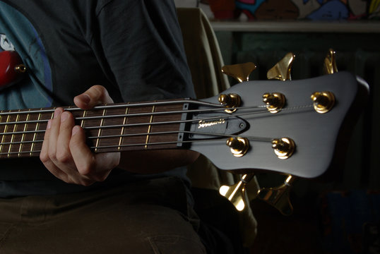 Playing an bass guitar with brown neck