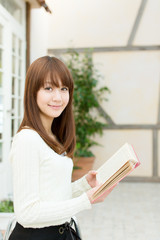 Obraz premium Beautiful young woman reading a book