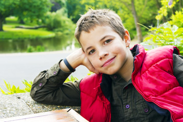 Cute teenage boy smiling against green background - 48391684