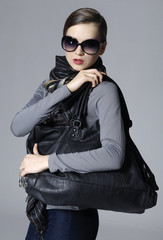 Fashion stylish girl with black bag posing