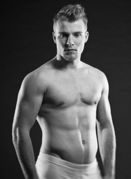 Muscled fitness man. Black and white studio shot.