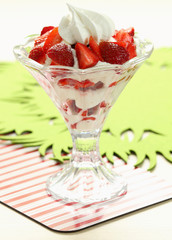 Strawberries with whipped cream in glass cup