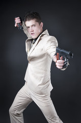 Fototapeta na wymiar atrakcyjny mężczyzna z bronią na sobie biały garnitur
