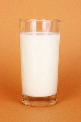 Glass of fresh new milk on brown background