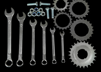 Machine gear, metal cogwheels, nuts and bolts isolated on black