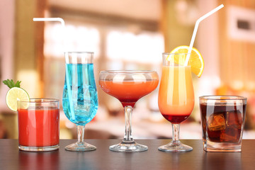 Several glasses of different drinks on bright background