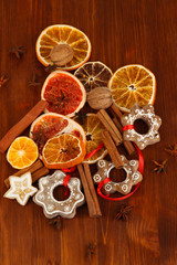Obraz na płótnie Canvas Suszone owoce cytrusowe, przyprawy i ciasteczka na drewnianym stole