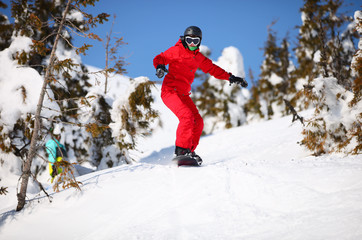 Fototapeta na wymiar Kobieta snowboarder będzie skakać na zboczu góry