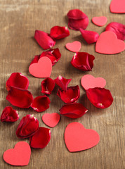 Rose petals and heart shaped on wooden background