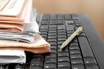 Pile of Newspapers on the Computer Keyboard close up