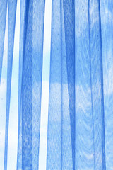 Curtain on window against blue sky abstract background texture