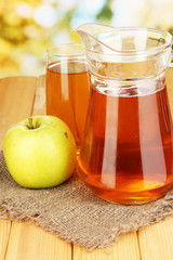 Full glass and jug of apple juice and apple