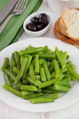green beans on the plate with olives and bread