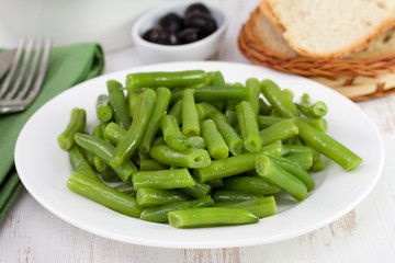 boiled beans on the plate with olives and bread