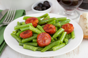 boiled green beans with chorizo on the plate