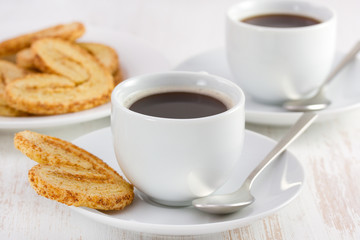 two cups of coffee with cookies