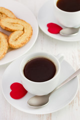 cups of coffee with spoon and cookies
