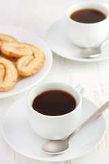 Obraz premium two white cups of coffee with cookies