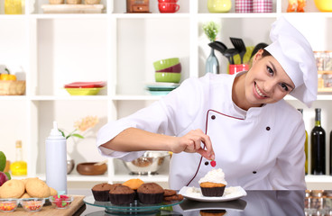 Young woman chef cooking cake in kitchen