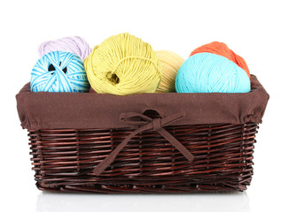 Colorful yarn balls in wicker basket isolated on white