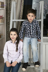 Fototapeta premium cute little boy and sister sitting on staircase
