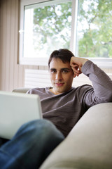 Young man on a sofa with a laptop