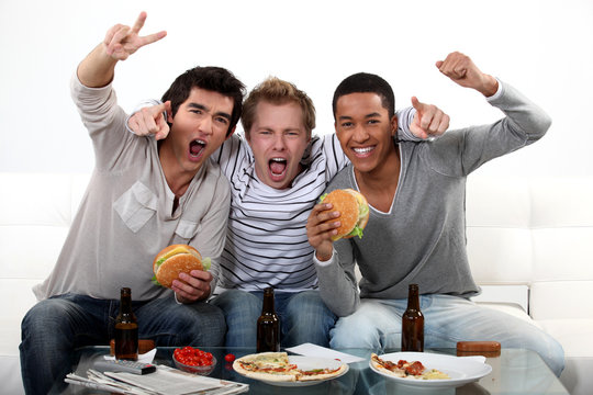 three friends eating while watching television