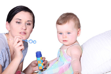 Mother with baby blowing bubbles