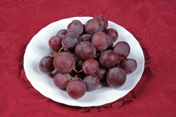 Red grapes on white plate © Arena Photo UK