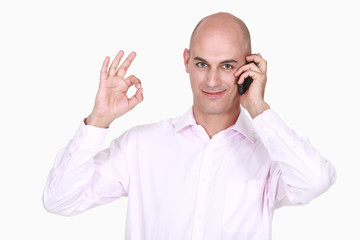 Man on phone doing OK sign