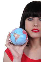 Serious beautiful woman with the world in her hand