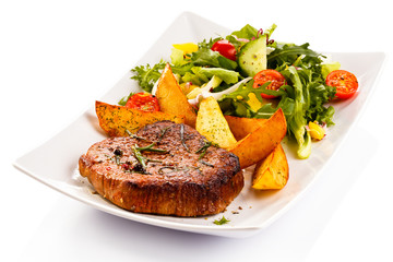 Grilled steak, baked potatoes and vegetables
