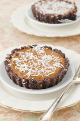 Chocolate tarts with cream and coffee closeup