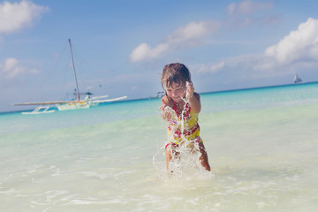 Fototapeta premium happy smiling child girl playing in water